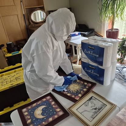 Technician in protective equipment performing environmental cleaning